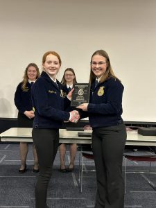 OESJ Student Kaylee Heroth SHakes hands with and FFA presenter