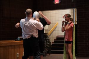 Sweethearts & Heroes Co-Founder Tom Murphy stretches a rubber cap over a students head