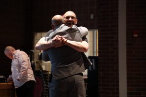 Sweethearts & Heroes Co-founder Tom Murphy Hugs OESJ Superintendent Adam Heroth at the conclusion of his presentation.