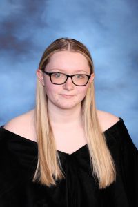 A snapshot of Lilly Johnson posing for her senior picture portrait.