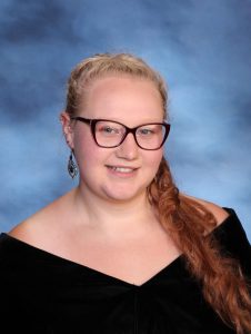 A snapshot of Emily Sheldon posing for her senior picture portrait.